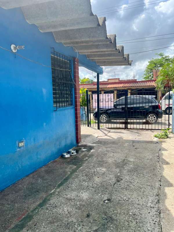 Driveway gate and blue wall next to house Villa Venus Juan Díaz Panama