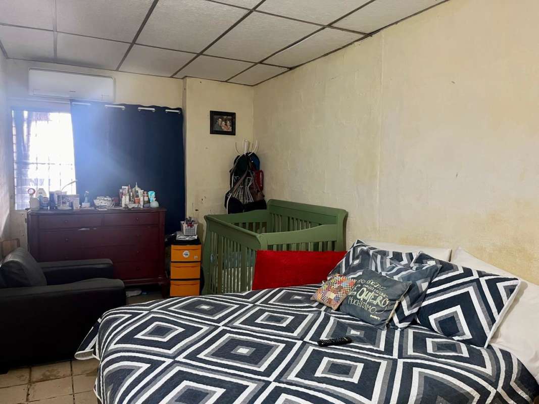 Bedroom with bed crib armchair and window with curtains Villa Venus Juan Díaz Panama