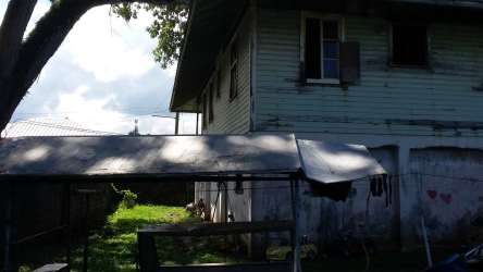 Gated property with banana plants, mature trees, stone wall and gravel drive central Colón