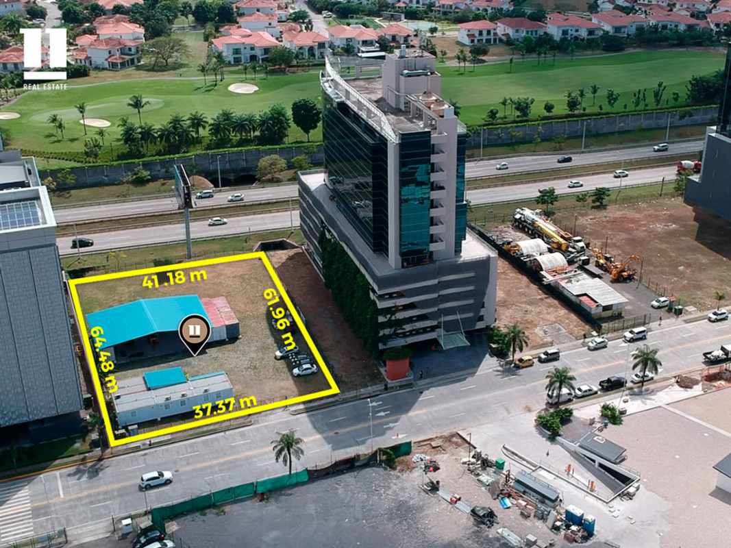 Vacant lot with billboards and adjacent office buildings in Santa María Business District Panama