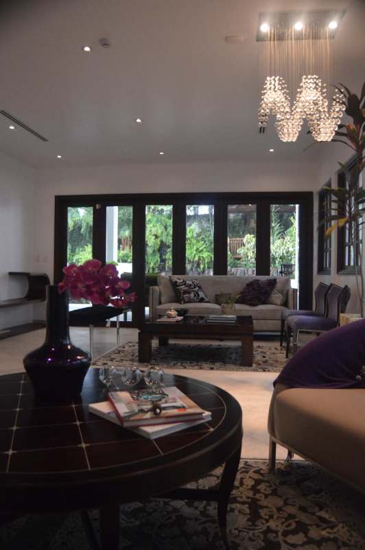 Elegant living room with chandelier, wood floors, neutral decor in luxury house La Loma Panama City
