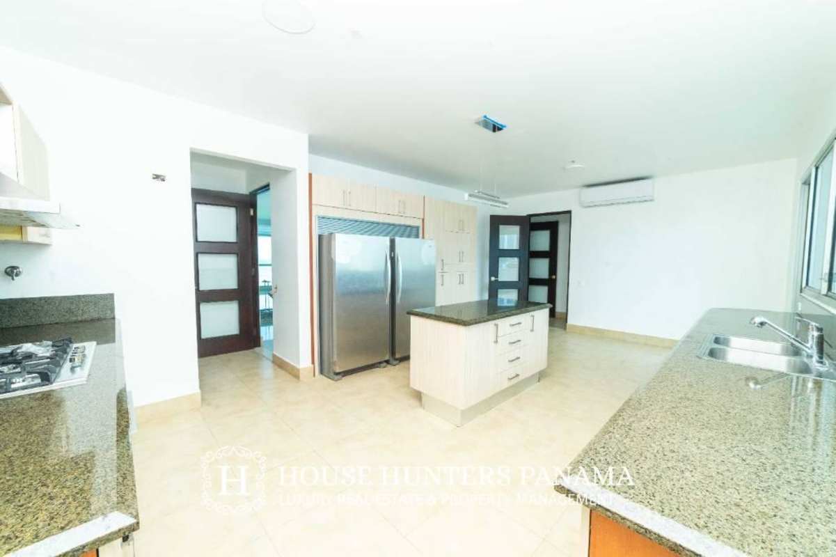Luxury kitchen with granite island, stainless appliances, wood cabinetry in PH Ten Tower Costa del Este