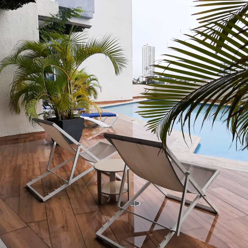 Modern outdoor swimming pool terrace with sunbeds city backdrop at PH Coral Towers Panama City