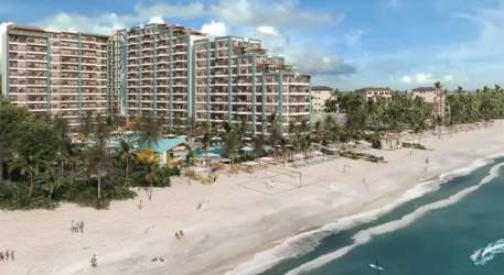 Beachfront resort complex with high-rise condos, balconies, pool and ocean waves at Margaritaville Playa Caracol Panama