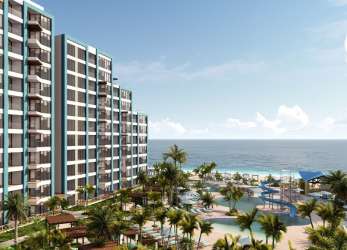 Resort style swimming pool with ocean view, palm trees and beachfront condos at Playa Caracol Panama