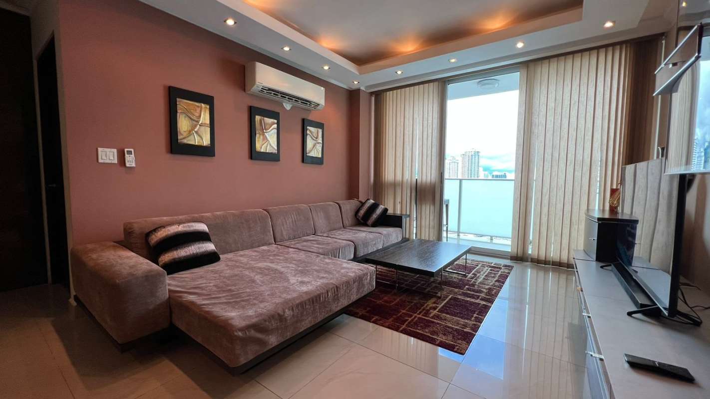 Small bedroom with beige walls, pink bedding, split AC and wall mounted TV PH Pacific Sun Panama