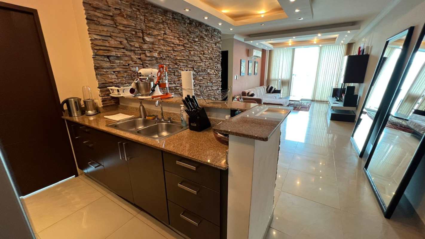 Bright living room with sectional sofa, large windows and city views at PH Pacific Sun Punta Pacifica Panama