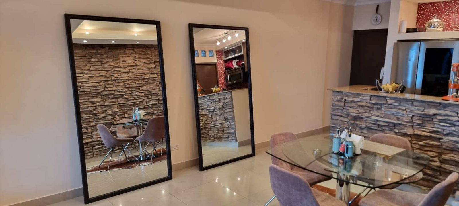 Dining area with glass table, stone accent wall and open layout at PH Pacific Sun Panama