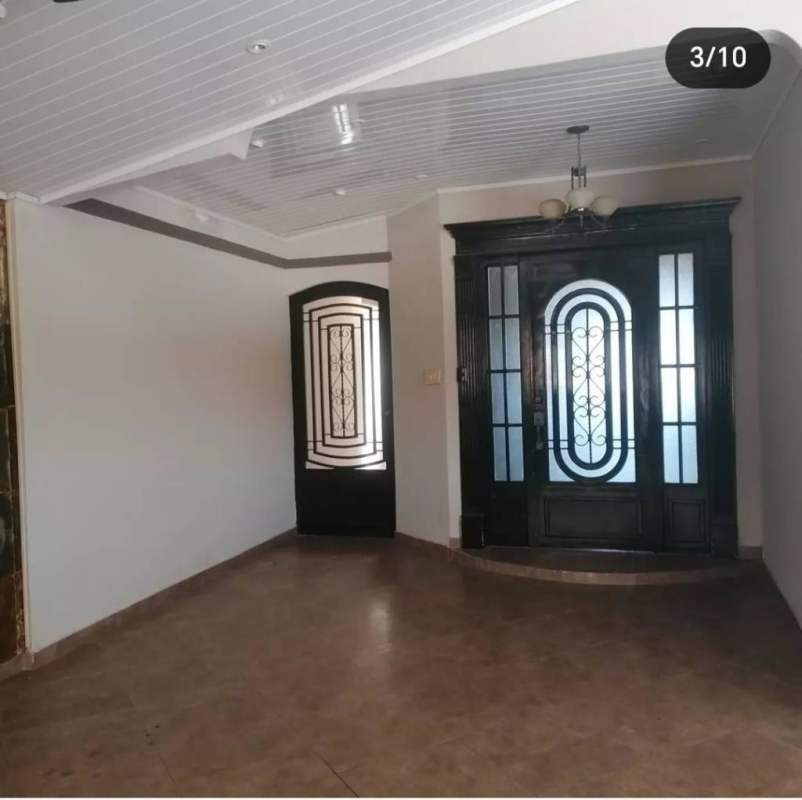 Kitchen with wood cabinets, double sink, range hood, tiled backsplash in house Panama City