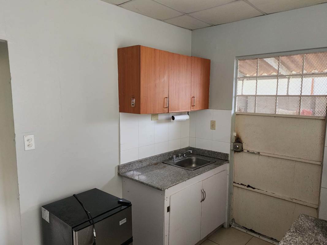 Living room with large sliding windows, tiled floors and ceiling fan in house for sale Las Cumbres Panama