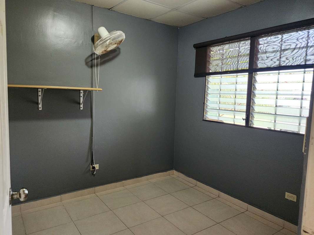Empty bedroom with security window bars and tiled floor in Brisas del Lago Panama City
