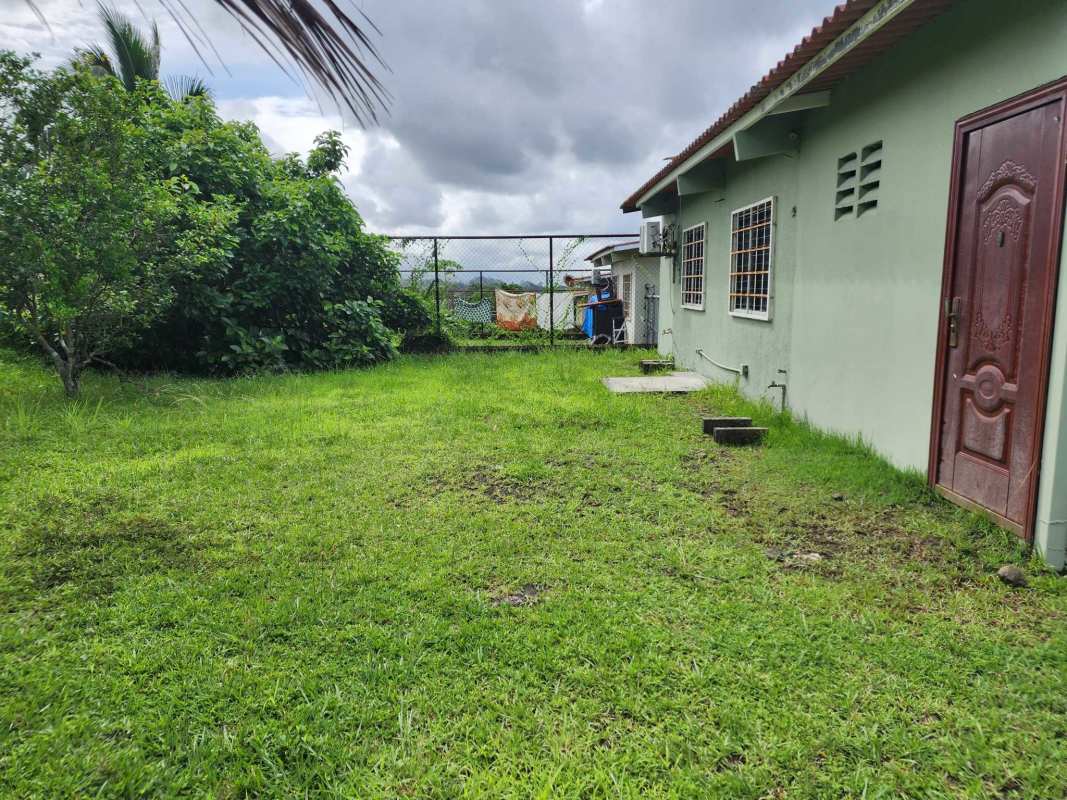 House exterior with fenced yard, green lawn and AC unit, Las Cumbres Panama City