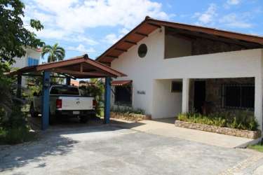 Beach house facade with tiled roof, carport parking, landscaping in Gorgona Panama beachfront residence