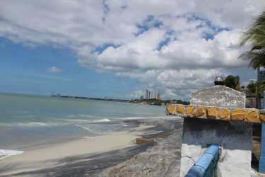 Coastline with urban skyline distant, seawall and sandy beach in Gorgona Panama real estate