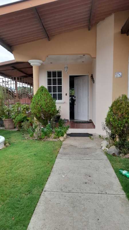 Manicured front garden and wrought iron gate at corner house Brisas del Golf Panama