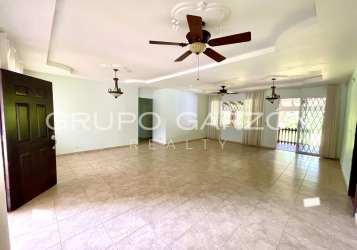 Large bright living room ceramic floors ceiling fans garden view in Howard home Panama Pacifico