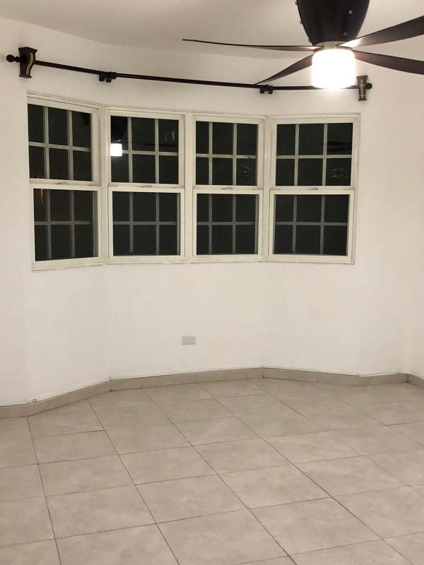 Bright living room with bay window and ceiling fan in Villas del Golf Panama