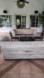 Enclosed sunroom patio with wicker seating set, tiled flooring Playa Serena Coronado Panama