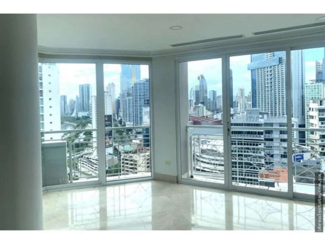 Living room with full glass windows showing city skyline and ocean in PH City Tower Punta Paitilla