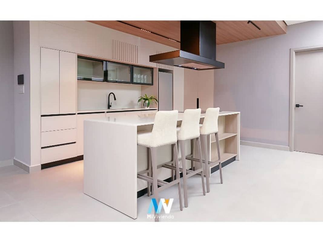 Minimalist kitchen with island seating and built-in appliances at PH Uptown Avenida Balboa Panama
