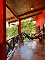 Covered rustic balcony with hammock and views of lush tropical forest in Altos del María community