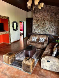 Exterior colorful facade of tropical-style house with patio and lush garden in Altos del María Panama