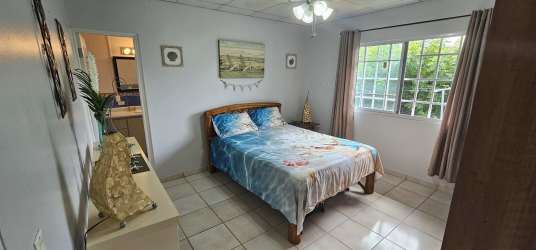 Bedroom featuring split AC unit, large windows, neutral floors and natural light at Cabuya Panama property