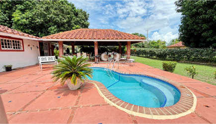 Private swimming pool with terracotta deck, covered terrace, and landscaping in Coronado Panama