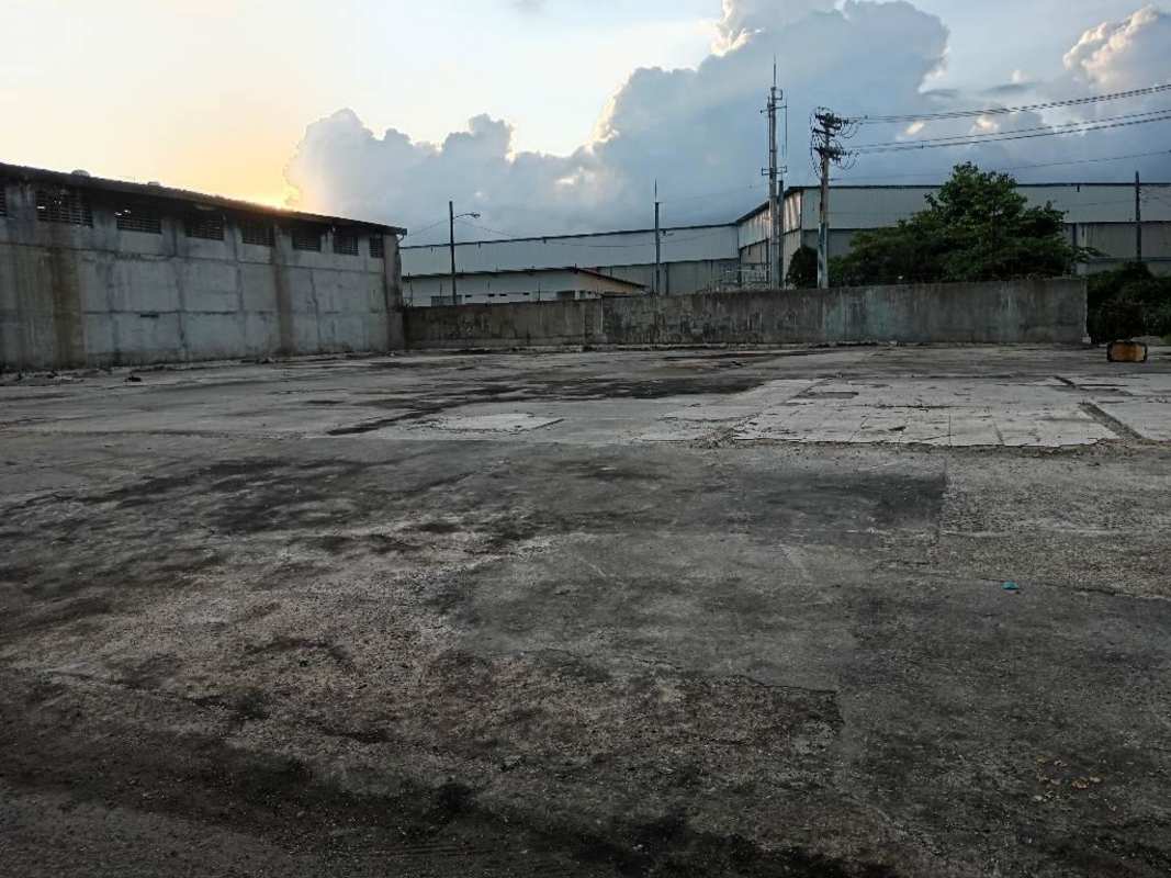 Empty paved industrial yard sunset view surrounded by boundary walls in Río Abajo Panama
