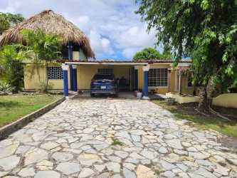 Covered terrace with wood beams and open dining space overlooking garden