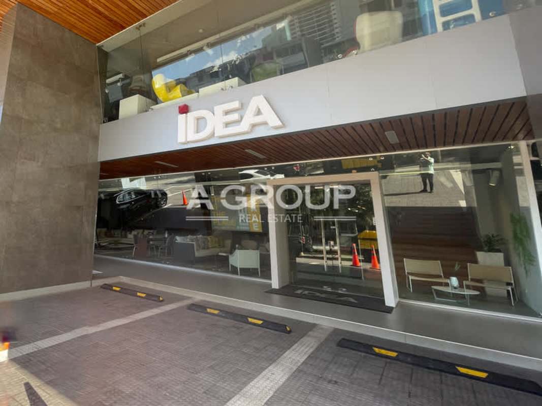 Kenex Plaza exterior with glass facade, retail signage, parking area Obarrio Panama City