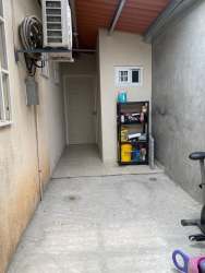 Narrow outdoor area with metal roof, AC unit, storage shelf at Colinas del Sol Arraiján home