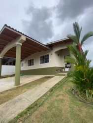 Front exterior view with covered parking, garden, arched veranda of house in Colinas del Sol Arraiján