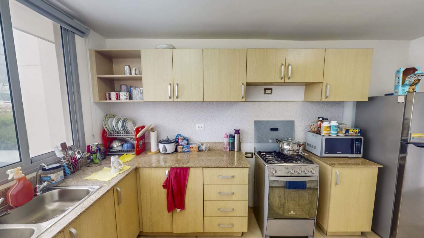 Closed kitchen with granite counters, appliances and window in PH Rokas Panama City apartment