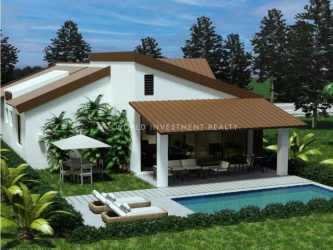 Modern home with sloped roof, carport area, lighting and landscaped front at sunset in Terra Viva