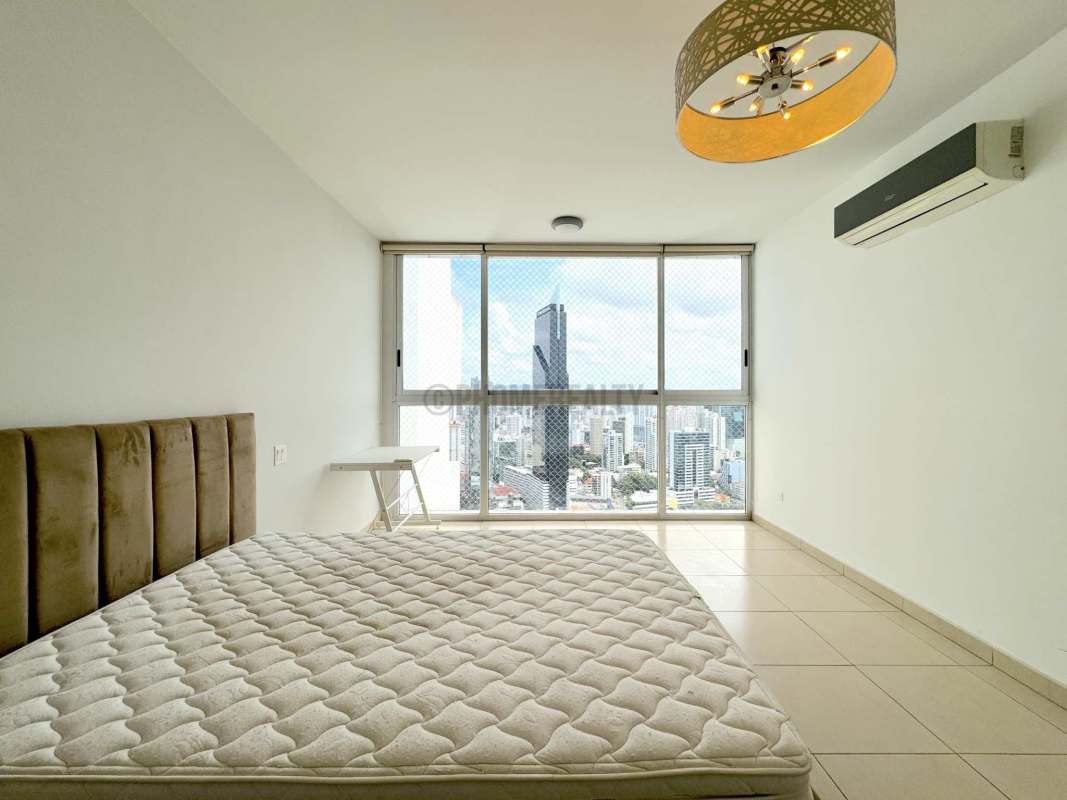 Contemporary bedroom with large windows featuring Panama skyline at Yoo Panama