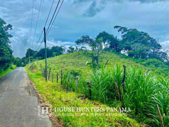 Paved country road with hillside and fencing accessing mountain lot Jaramillo Boquete Panama