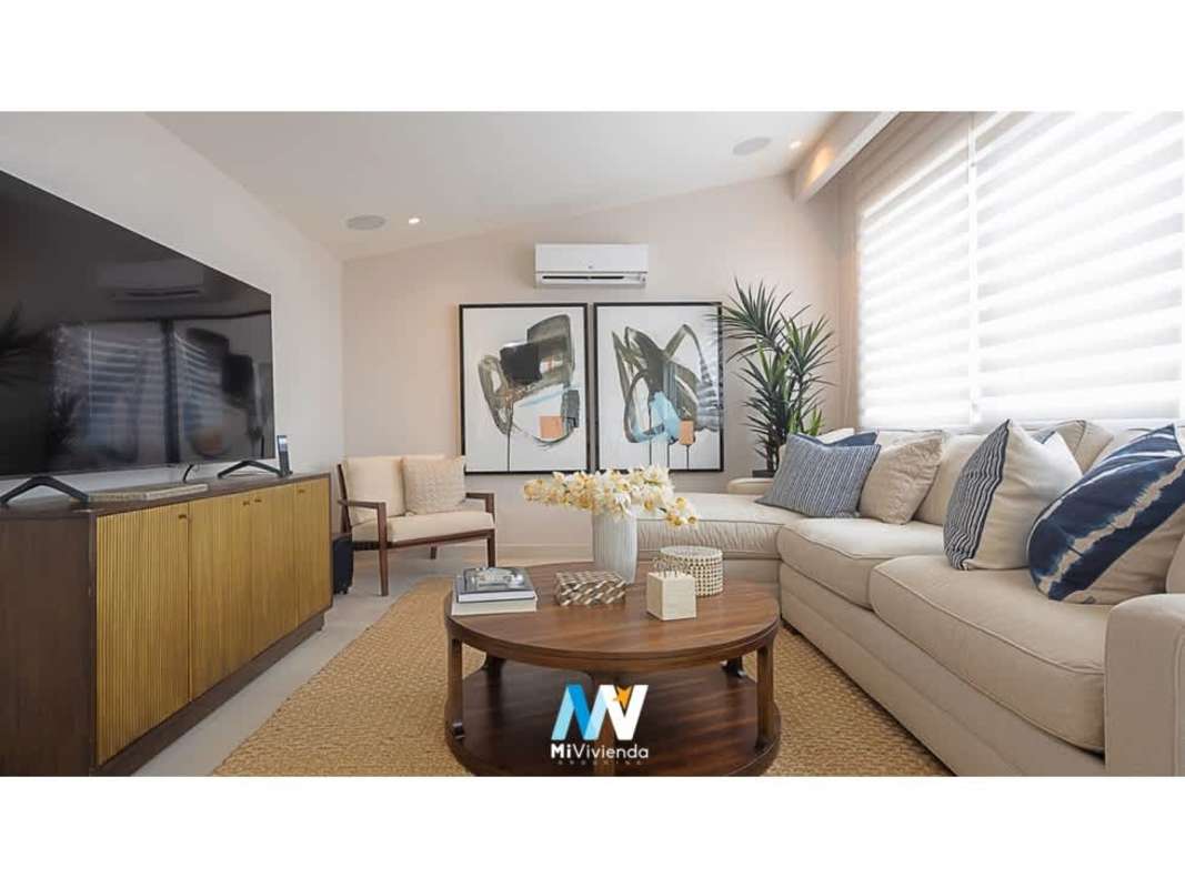 Modern living room with beige sofas, large windows at The Woods inside Santa Maria Panama