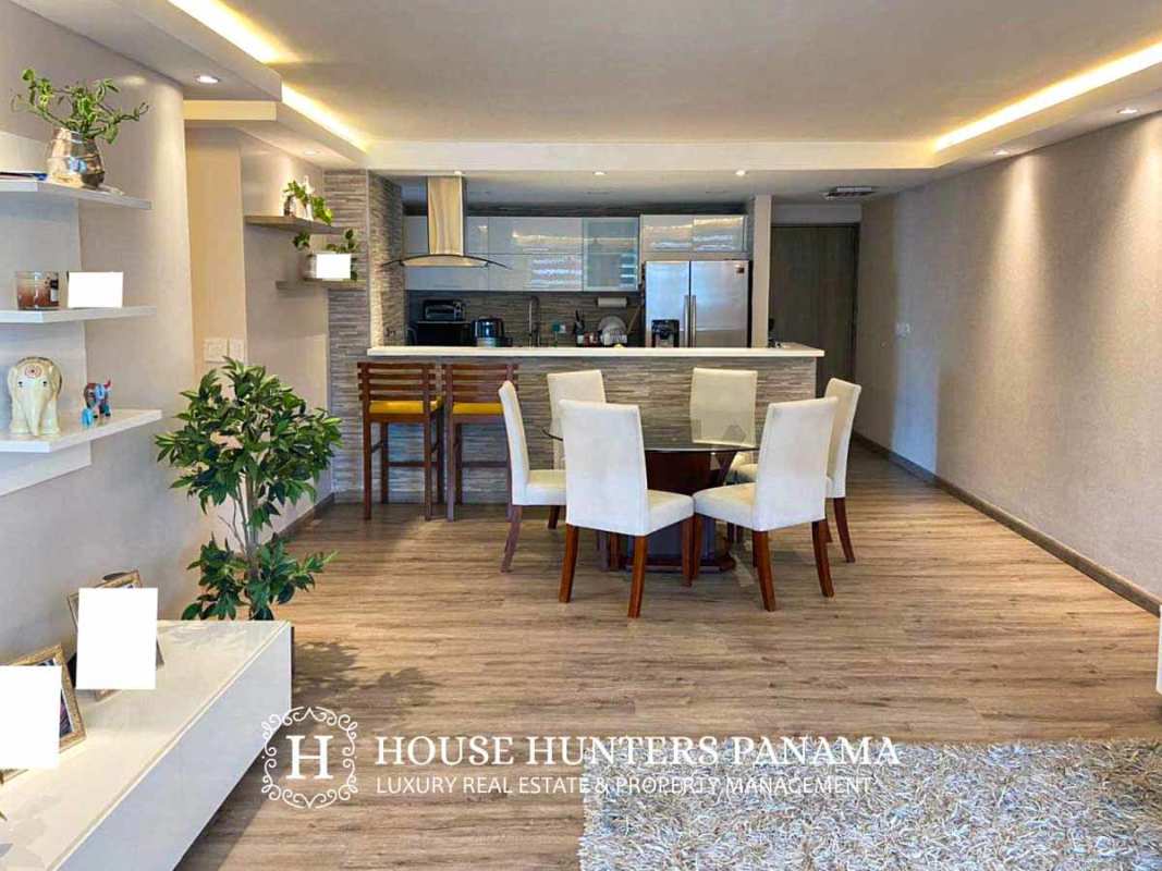 Living room with large beige sectional, balcony access and skyline views at PH Sunrise Tower Obarrio