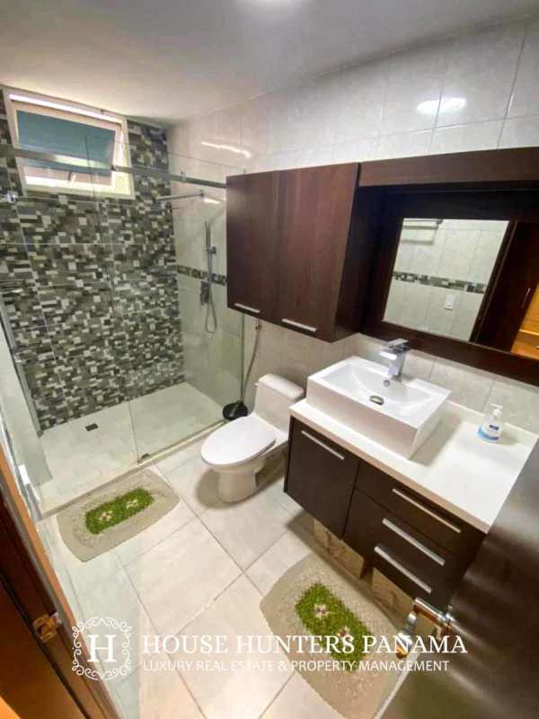 Open kitchen and dining area with wood flooring and glass dining table in PH Sunrise Tower Obarrio apartment