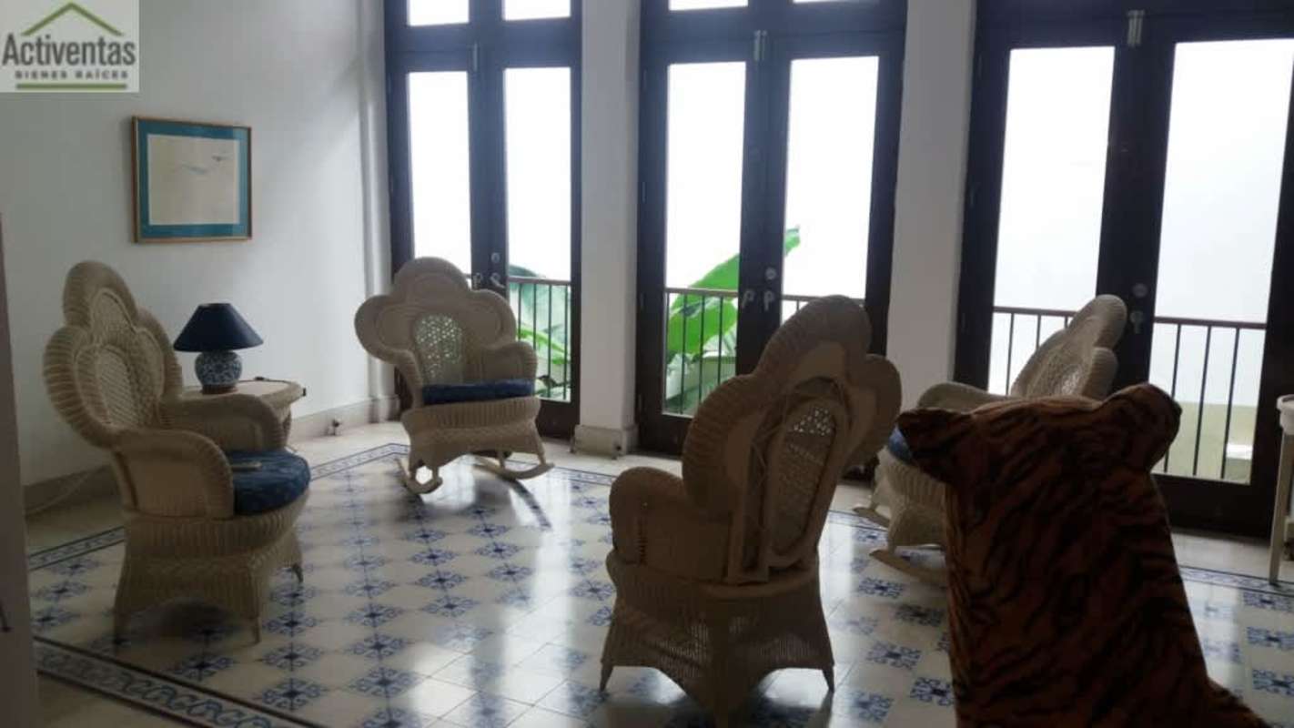 Bright colonial sitting area with wicker chairs and large balcony doors in Casco Viejo Panama
