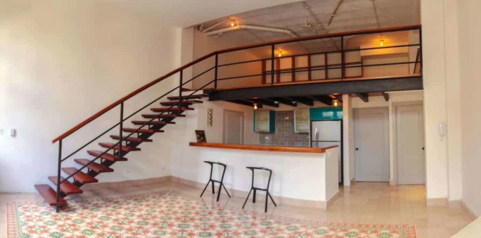 Industrial style open loft kitchen floating stairs artisanal tiles in Casco Viejo apartment Panama sale