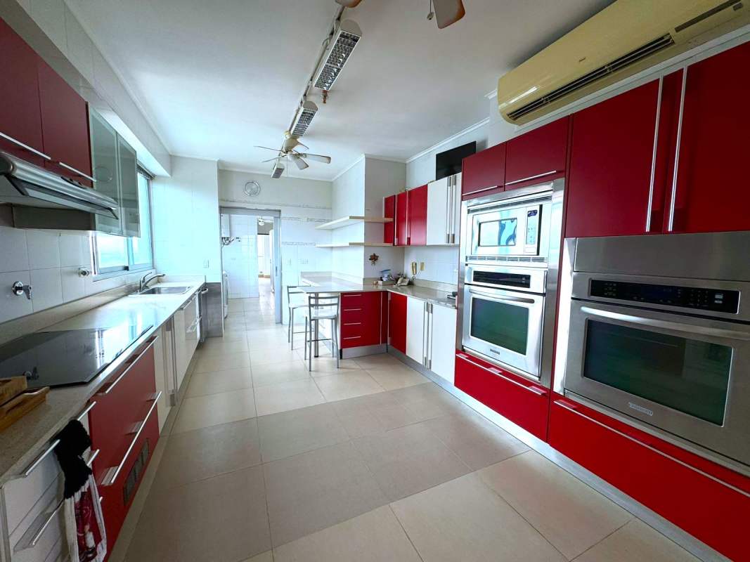 Spacious kitchen with red cabinetry, built-in appliances and city views at PH Park One Panama