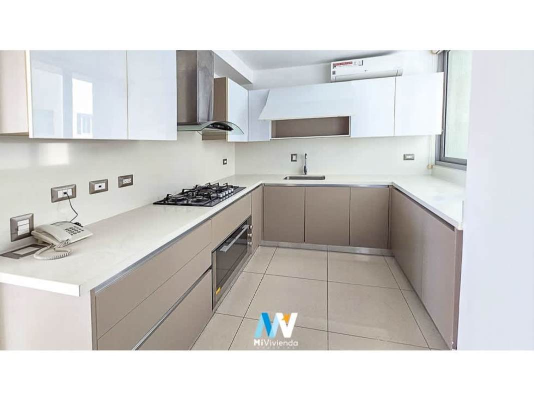 L-shaped modern kitchen with white counters, oven, range hood in PH Bali apartment for rent