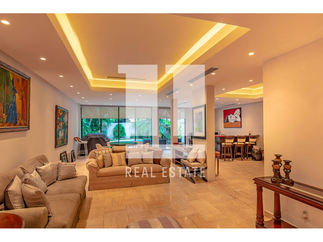 Spacious living area with entertainment wall, sectional sofas and terrace view in house for sale in Panama