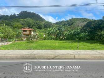 Clear flat lot in Alto Boquete with paved road access and mountain backdrop, ideal commercial or residential project