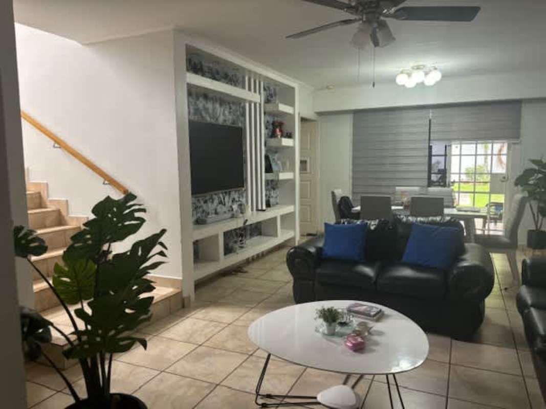 Fenced backyard with tropical plants and green lawn in duplex Brisas del Golf Panama