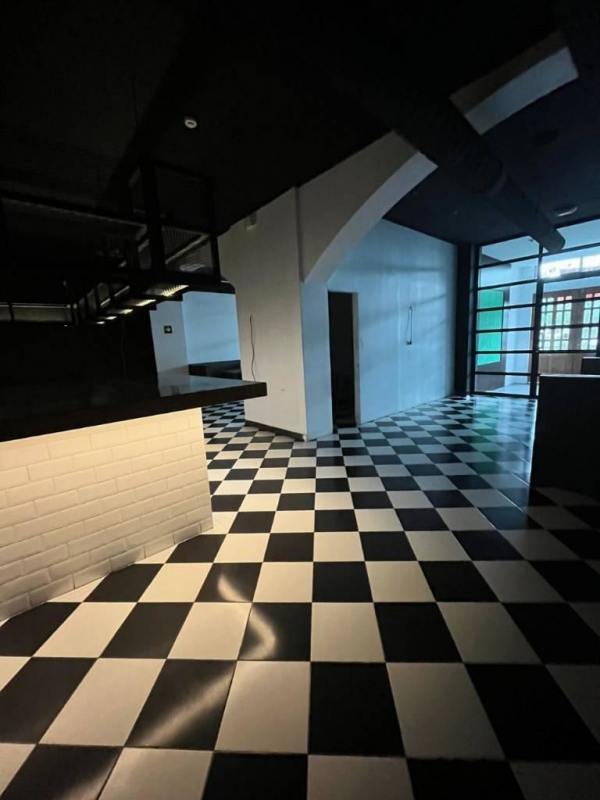 Spacious commercial interior with black and white tile floor and large windows at Casco Viejo entrance Panama
