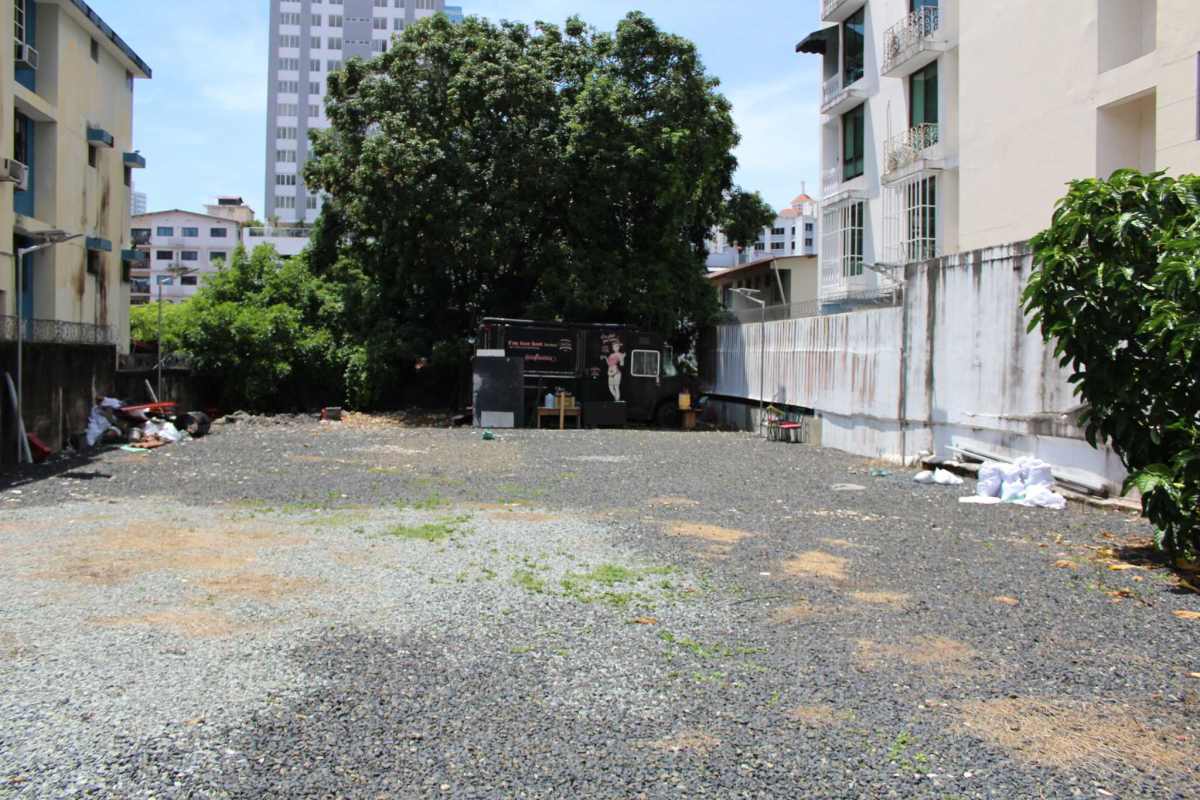 Urban development lot on paved road with trees and adjacent buildings in San Francisco Panama