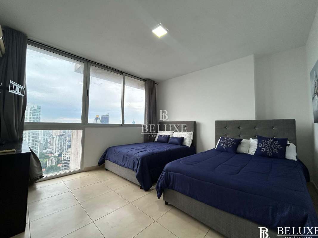 Modern furnished bedroom with floor-to-ceiling windows and skyline plus ocean view at PH White Tower Avenida Balboa